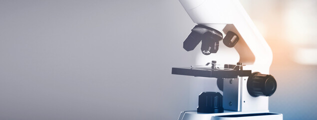 Microscope on blurred background, closeup. Banner design with space for text