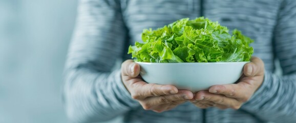 Full body shot of a fit individual holding a bowl of salad with natural lighting and copy space