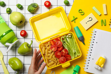 Yellow lunch box with food on a light background