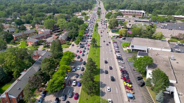 Aerial view of row of classic cars among regular cars at wood ward dream cruise in Detroit, Michigan.