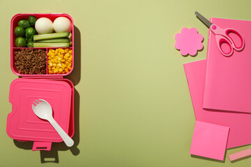 Pink lunch box with food, scissors and pink paper