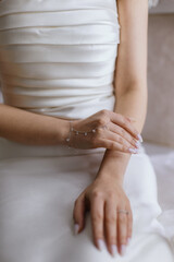 the body of a lady in decorated, white dress, putting white scarf and wearing a ring