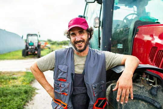 Portrait of a middle aged male farmer on field with tractor