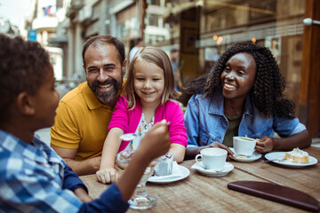 Happy multiethnic family enjoying time at a cafe together