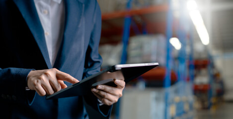 Close up, Woman worker or supervisor uses a digital tablet to check the stock inventory, a Smart...