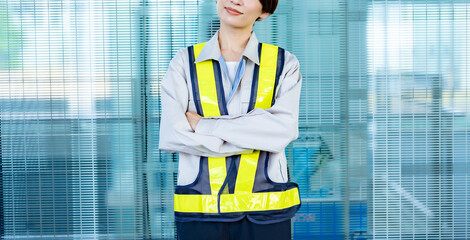 腕組をする作業着を着た女性