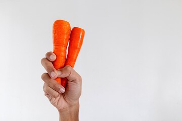 Hand holding fresh carrot isolated on white background