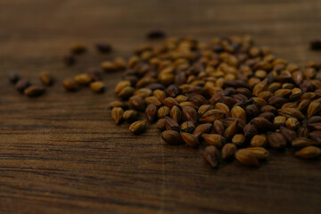 roasted barley grain on a wooden table. food background