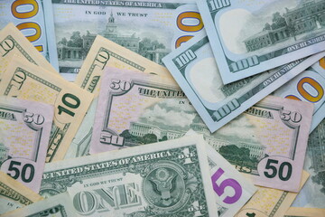 Big amount of US dollar bills in different nominations on table. Many dollar banknotes under natural light