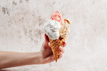 Women hand holding fresh and delicious ice cream in waffle cone