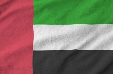 United Arab Emirates flag depicted on folded wavy fabric of old cloth close up