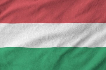 Hungary flag depicted on folded wavy fabric of old cloth close up