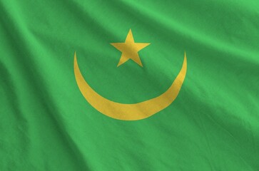 Mauritania flag depicted on folded wavy fabric of old cloth close up