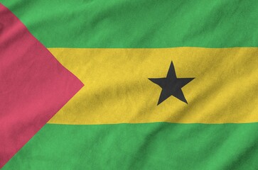 Sao Tome and Principe flag depicted on folded wavy fabric of old cloth close up