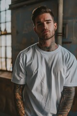 Obraz premium Oversize white style t-shirt mockup photo with handsome man with tattoos and light concrete background