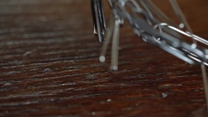 Magnetic force attracts metal paper clips from the table close-up