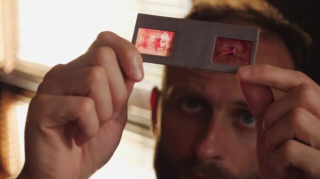 Close-up of a man looking at photo slides