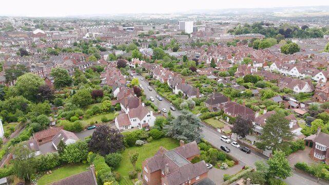 Aerial view of an upscale city street lined with detached houses, showcasing elegance and green surroundings in Exeter, UK