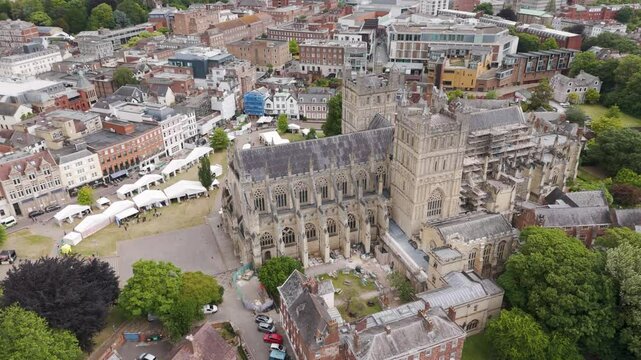 Drone orbital view showcasing the intricate architecture of Exeter Cathedral surrounded by lush greenery, Exeter, Devon, UK