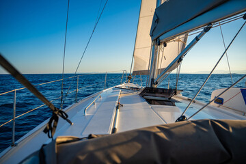 Yacht sailing in an open sea. Close-up view of the deck, mast and sails. Yachting concept