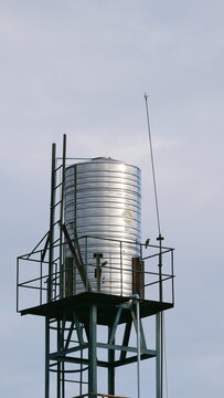 Elevated stainless steel water tank soars into overcast sky