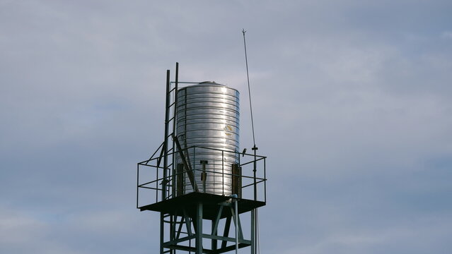 Elevated stainless steel water tank soars into overcast sky