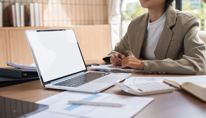 Business Team Collaborating and Taking Meeting Notes in a Modern Office Setting with Laptop and Documents