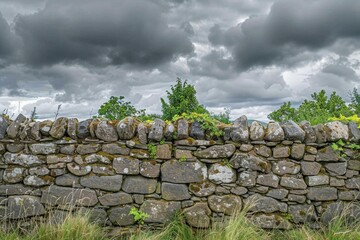View of old dry stone wall under a cloudy sky.