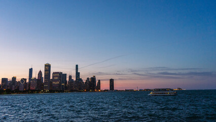 Fototapeta premium Downtown Chicago cityscape at sunset from across the bay, above the water. 
