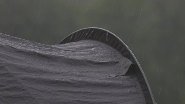 Raindrops on tent. Tourist equipment in wildlife in wet season. Close-up shot of raindrops on the tent. Rain is pounding on tent. Slow motion video ProRes 422 10bit ungraded C-LOG