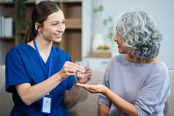 young caregiver assists her elderly woman patient at a nursing home. senior woman is assisted by a nurse at home.