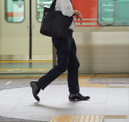 Obraz premium 夏の駅のホームで歩く一人の男性サラリーマンの姿