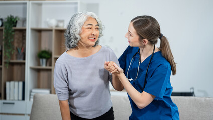 young caregiver assists her elderly woman patient at a nursing home. senior woman is assisted by a nurse at home.