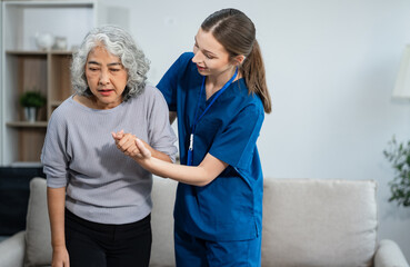 Obraz premium young caregiver assists her elderly woman patient at a nursing home. senior woman is assisted by a nurse at home.