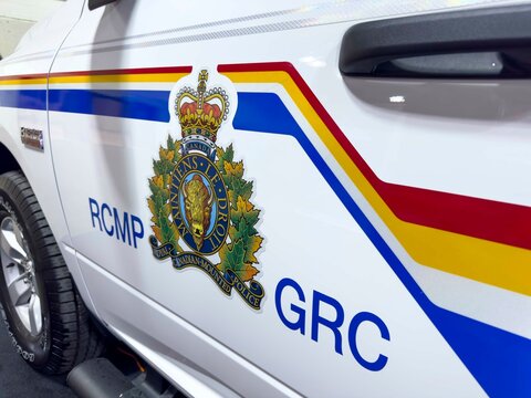 Calgary, Alberta, Canada. Jul 14, 2024. A close-up of the driver's side door of a white RCMP marked police vehicle. The RCMP badge and "GRC" lettering are visible.