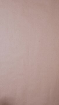 Women's hands unfold a roll of brown craft paper