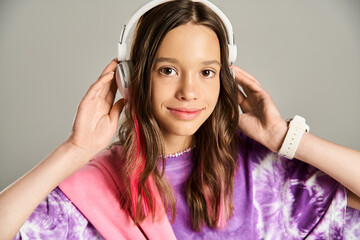 A stylish teenage girl in a vibrant purple shirt enthusiastically listens to music through...