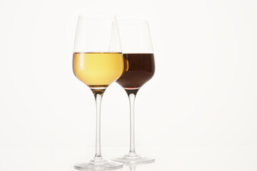 Two wineglasses half filled with red and white wine.