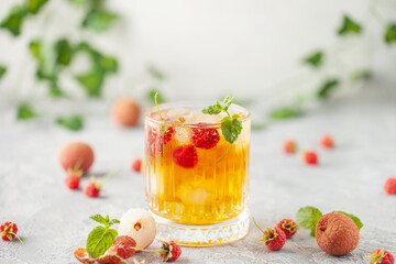 Lychee raspberry iced tea with mint leaves in glass. Summer drink