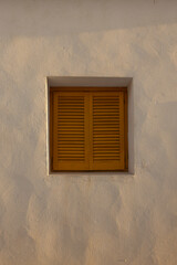 Yellow wooden window on a white wall