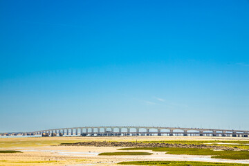 Bay of Chateau-d'Oleron and Ile d'Oleron bridge at low tide on a bright sun day Le Château-d'Oléron, France