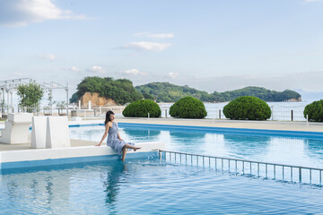 リゾートホテルのプールサイドにいる女性