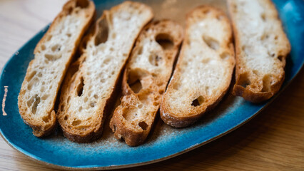A close-up of crispy, golden-brown baguette slices, showcasing their texture and holes. The image highlights the crunchiness and detail, ideal for culinary, bakery, or food-related content.
