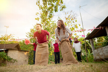 A group of people are playing a game of sack race