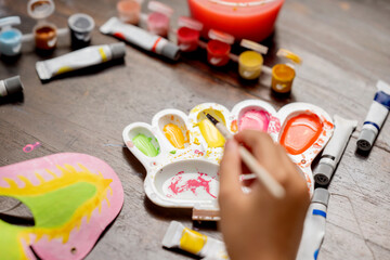 A little girl painting with a paintbrush and watercolor