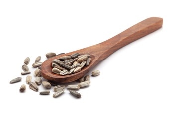 Front view of a wooden spoon filled with dry Organic Sunflower (Helianthus annuus) seeds. Isolated on a white background.