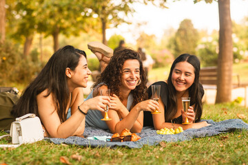 girlfriends laughing being happy at the park with a drink
