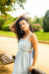 woman posing in the park with beautiful smile in blue dress