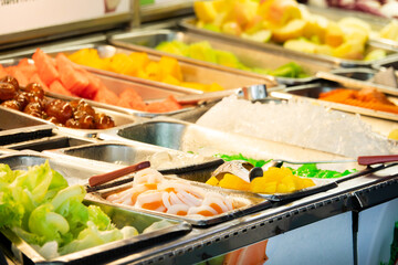 A buffet table with a variety of fruits and vegetables. The table is full of different types of fruits and vegetables, including apples, oranges, and carrots
