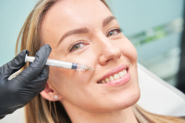 A Woman On A Cosmetic Treatment A closeup of a beautiful caucasian woman having a cosmetic procedure, filling wrinkles